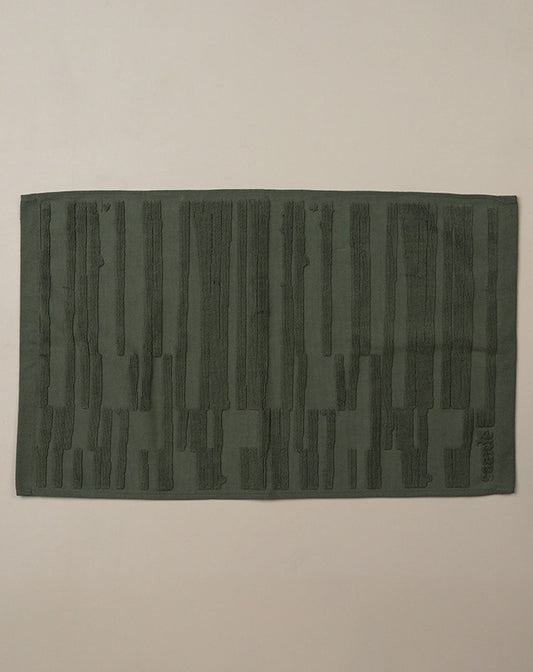 Dark green textured rug on a beige background