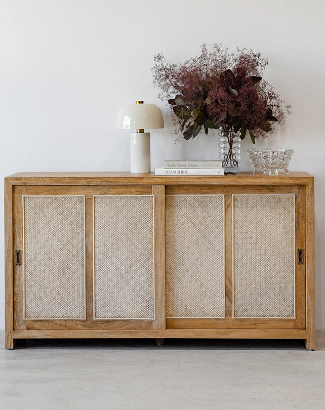 Wooden sideboard with decorative items against a white wall