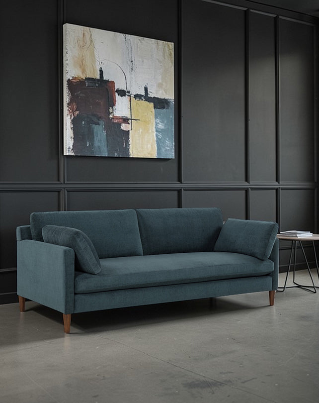 Blue sofa in a room with abstract art on the wall