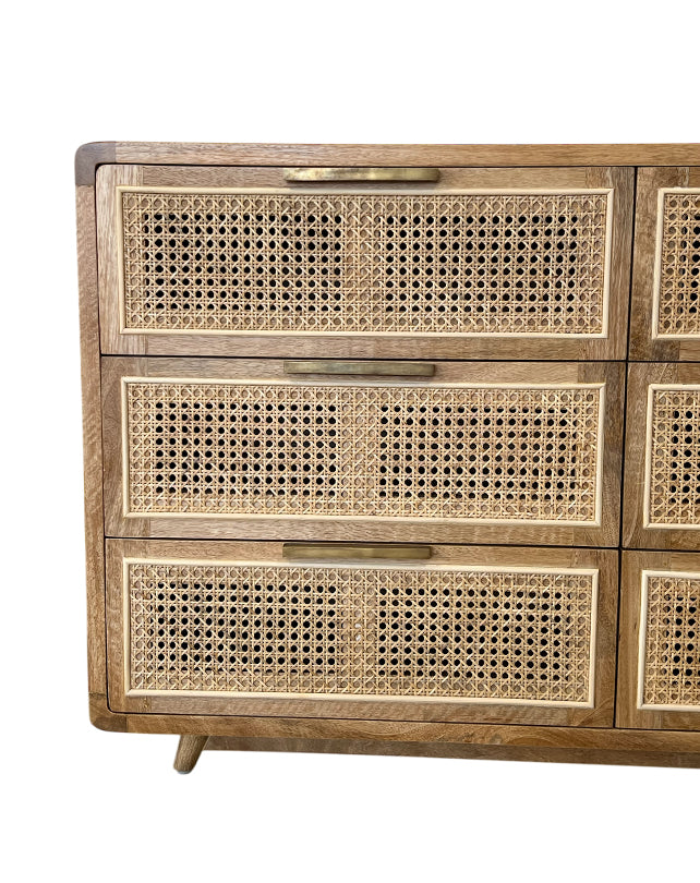 Wooden dresser with wicker drawers on a white background