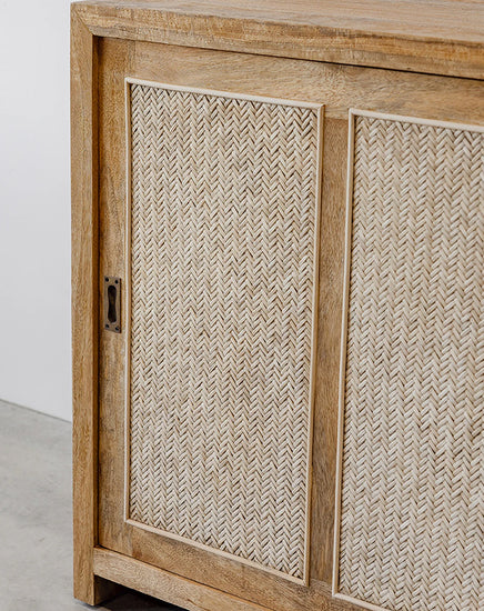 Wooden cabinet with woven design on doors against a white wall