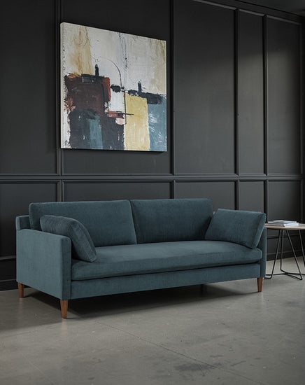 Blue sofa in a room with abstract art on the wall