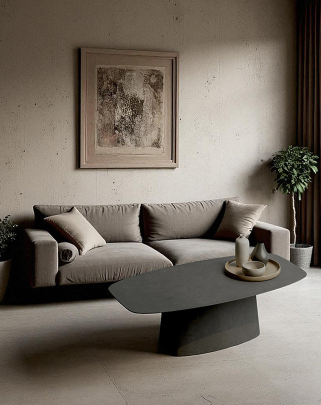 Modern living room with a gray sofa, coffee table, and framed artwork on a beige wall.