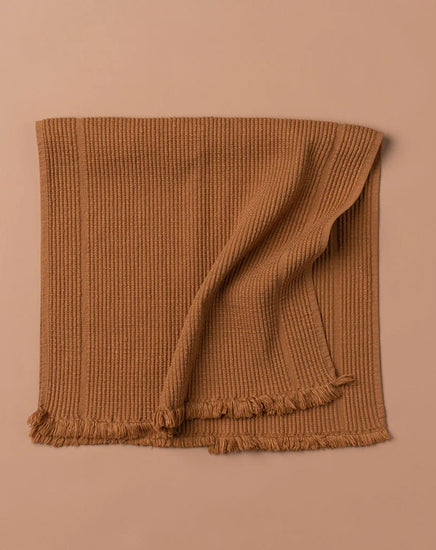 Brown textured blanket on a beige background