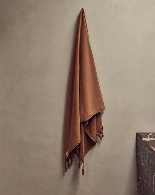 Brown towel hanging on a gray wall