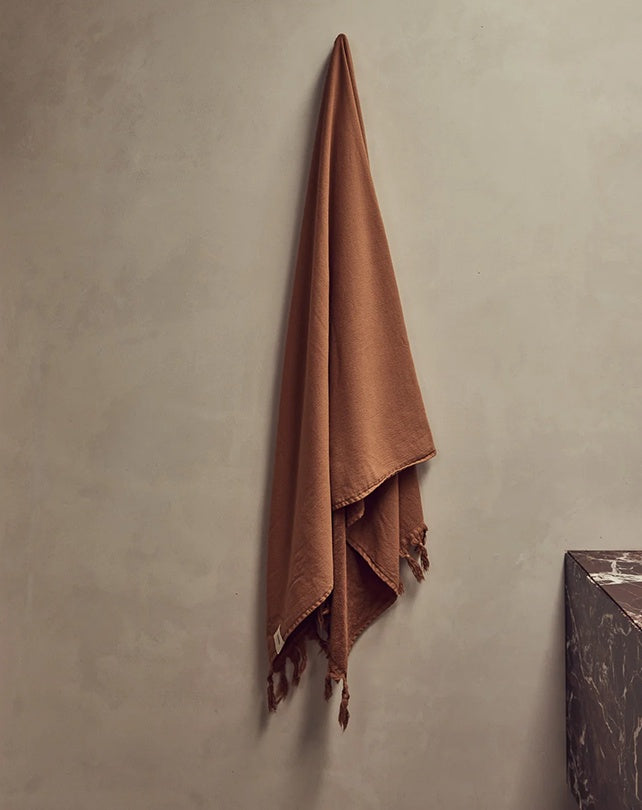 Brown towel hanging on a gray wall